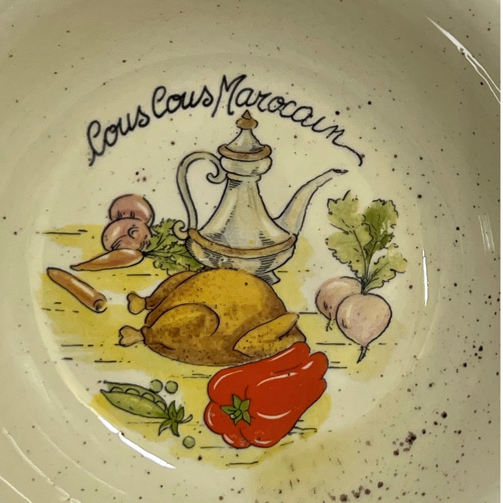 Decorative plate with illustrations of food and 'Couscous Marocain' text on a speckled background.