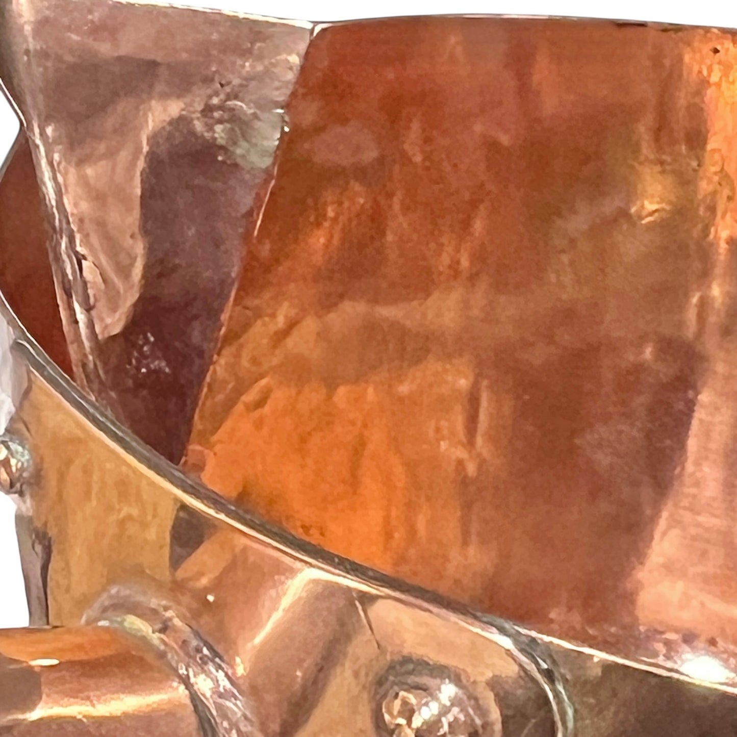 Close-up of a copper pot with a pouring spout on a white background
