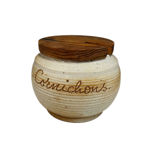 Ceramic jar with wooden lid labeled 'Cornichons' on a white background