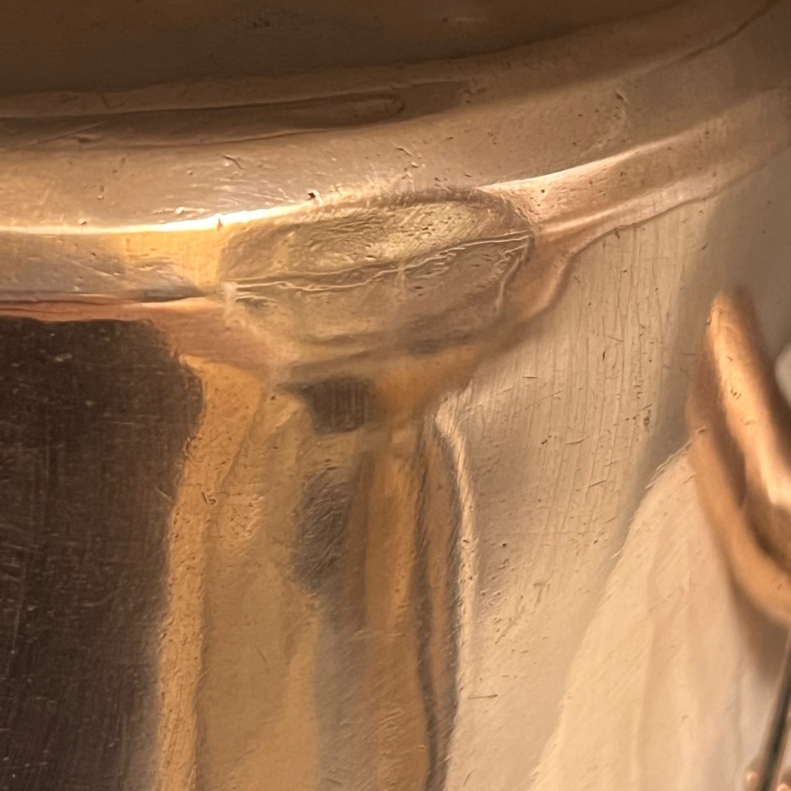 Close-up of a copper pot with a pouring spout on a white background