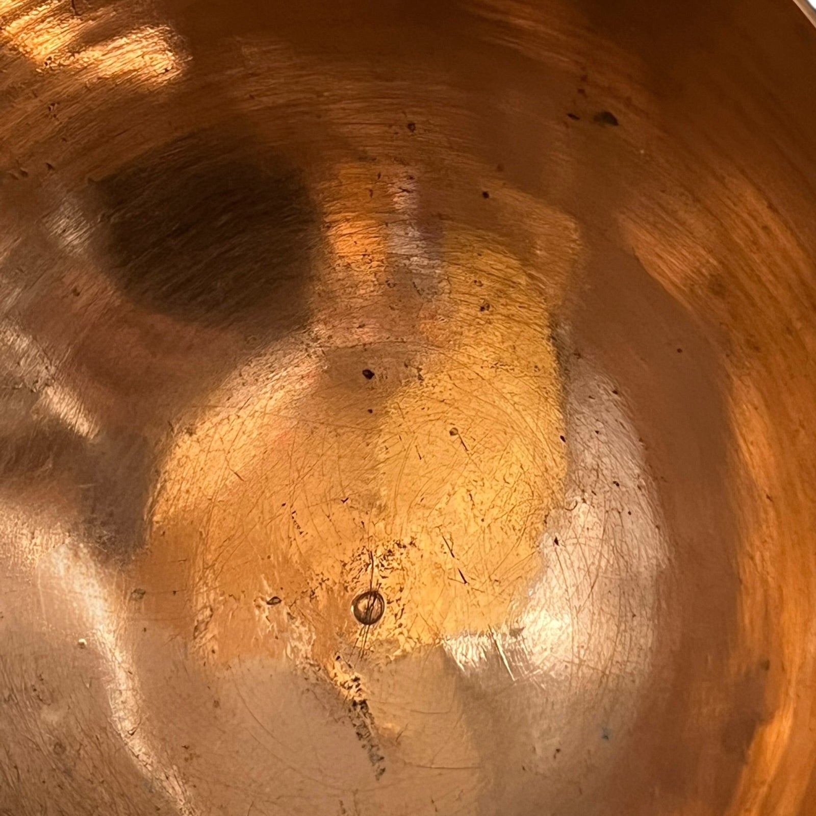 Close up of a French copper handmade ladle on a white background