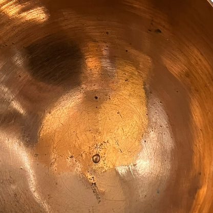 Close up of a French copper handmade ladle on a white background