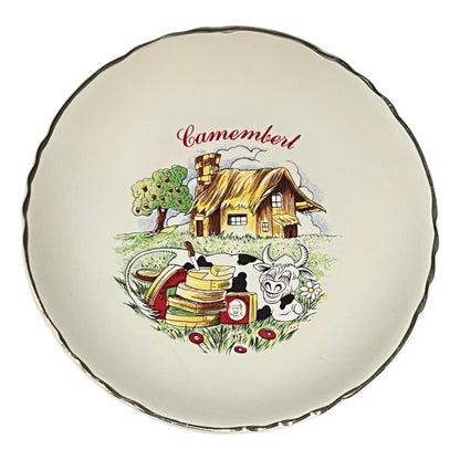 Decorative plate with a cartoon-style illustration of a cheese house, cow, and cheese stack on a white background.