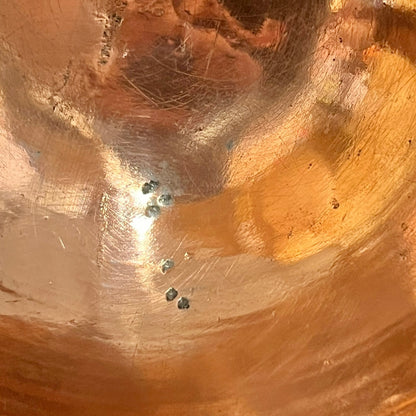 Close up of a French copper handmade ladle on a white background