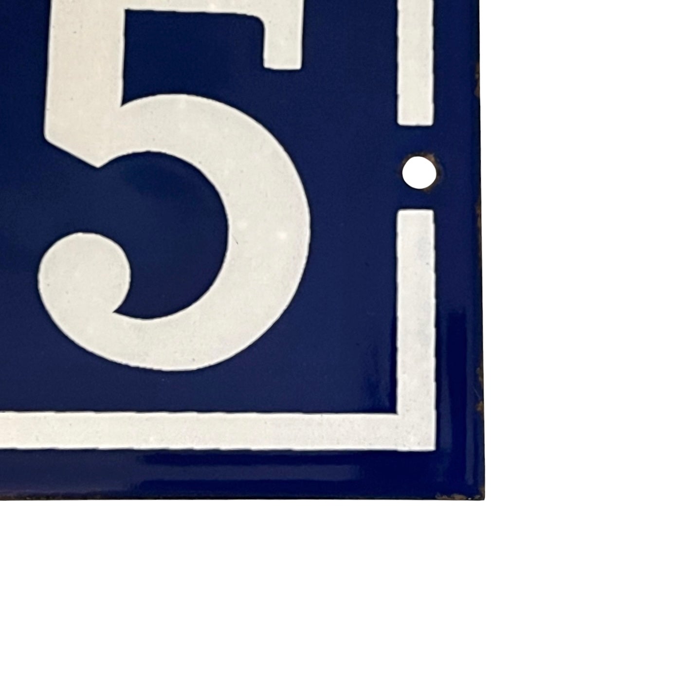 Close up of blue and white door number 65 on a white background 