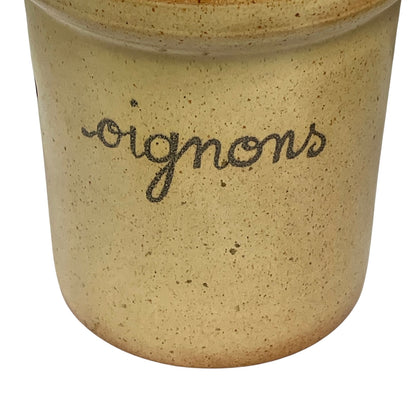 Close-up of a speckled beige ceramic pot with the word 'oignons' written in dark cursive script on the front, isolated on a white background.