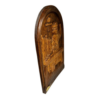 Wooden plaque with intricate carvings on a white background