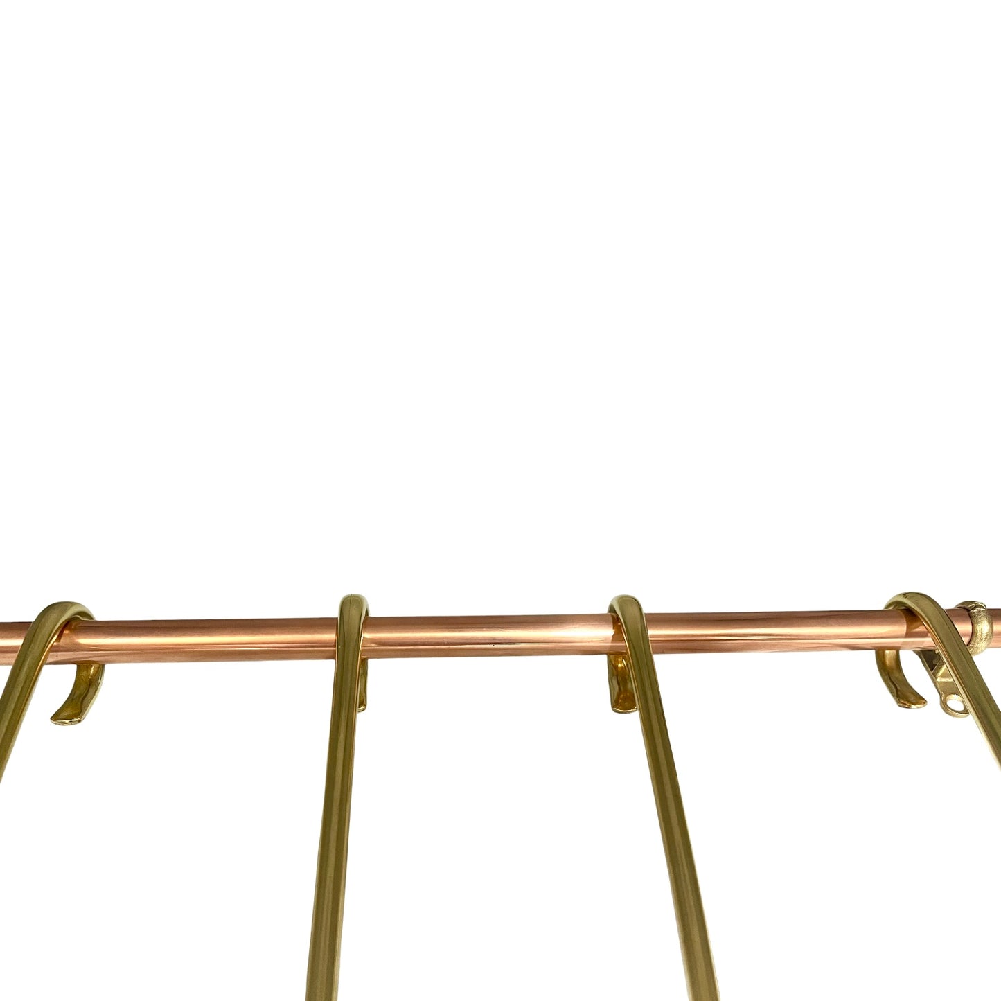 Close-up of a metallic gold and copper hanging rack bar with hooks against a solid white background.