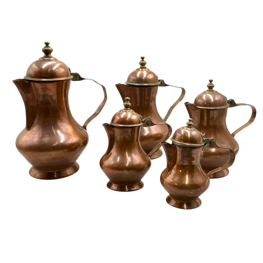 Set of five French vintage copper  pots with lids on a white background