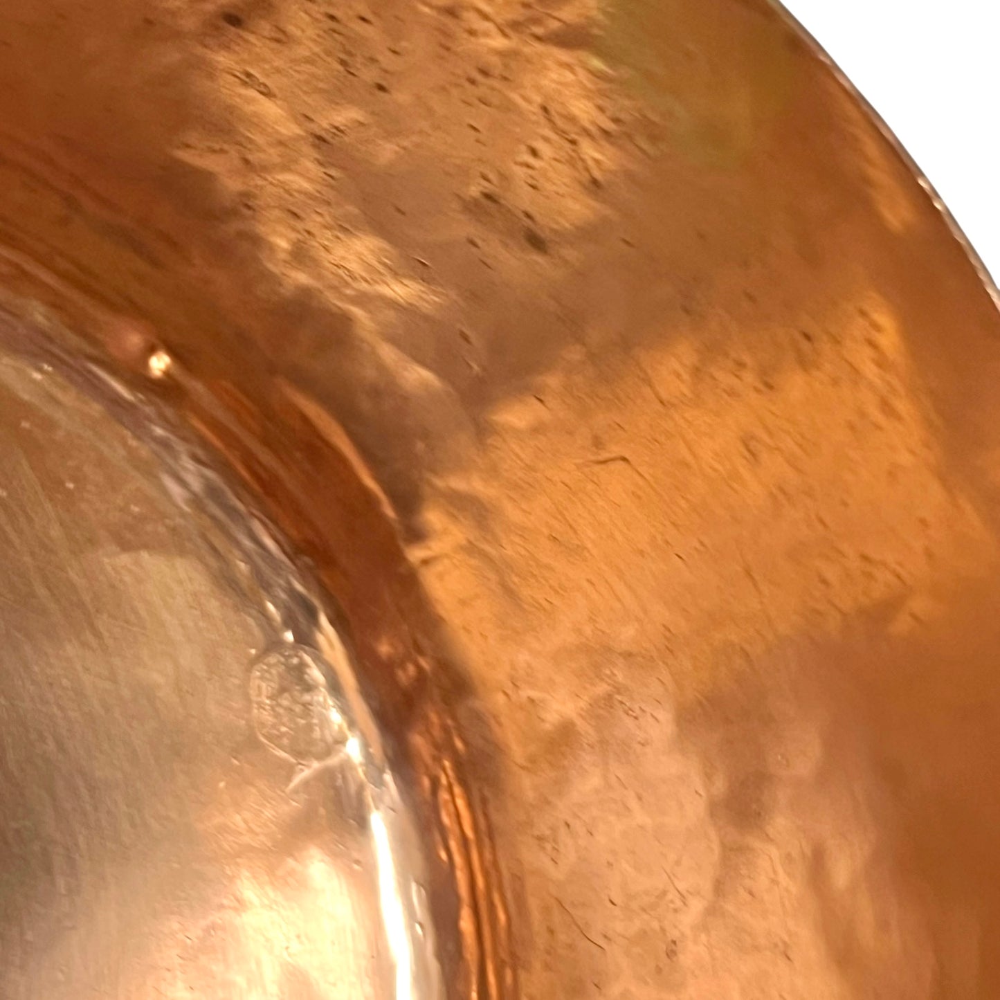 Close-up of a copper pot with a pouring spout on a white background