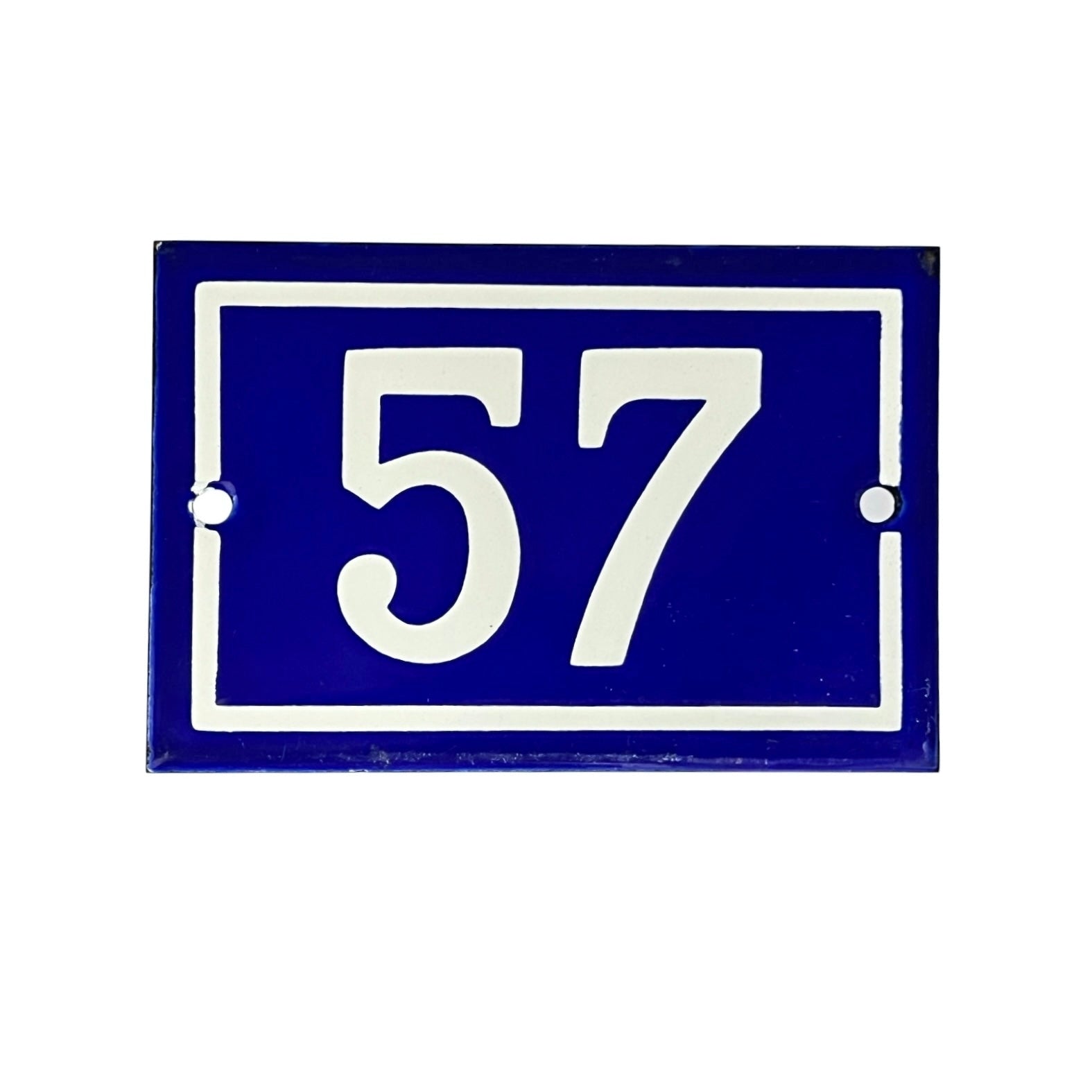 A rectangular blue house number plaque featuring the white numbers '57' inside a white border, shown on a plain white background.