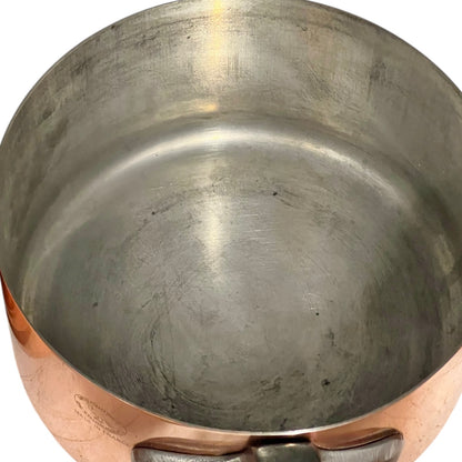 Close-up of copper cookware with iron handles on a white background