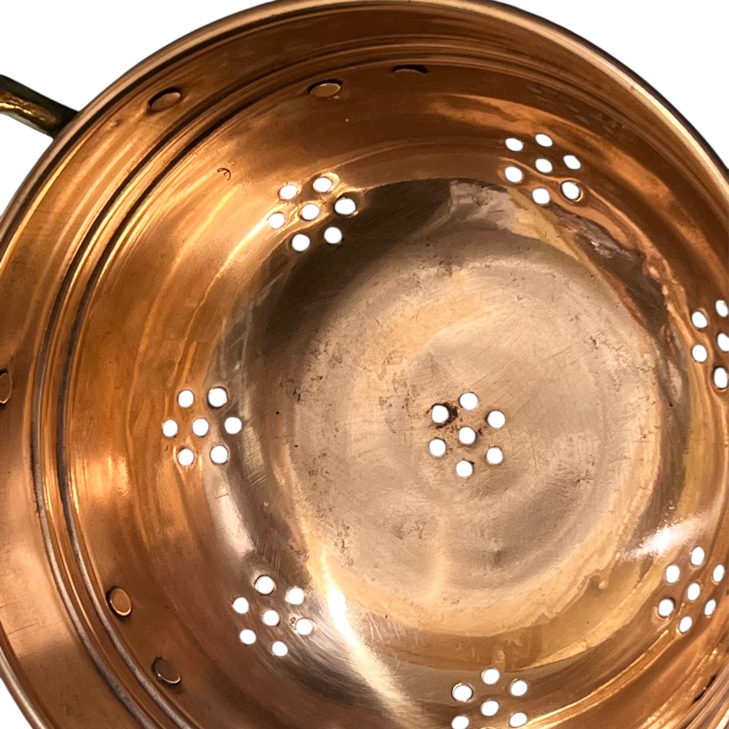 Copper colander with brass handles and feet on a white background