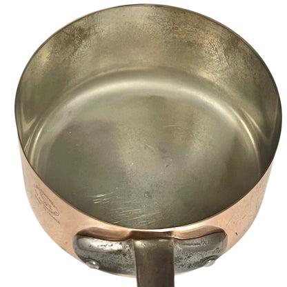 Close-up of copper cookware with iron handles on a white background