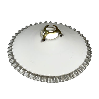 White round vintage glass lampshade with a frilled clear edge and a brass collar on a white background