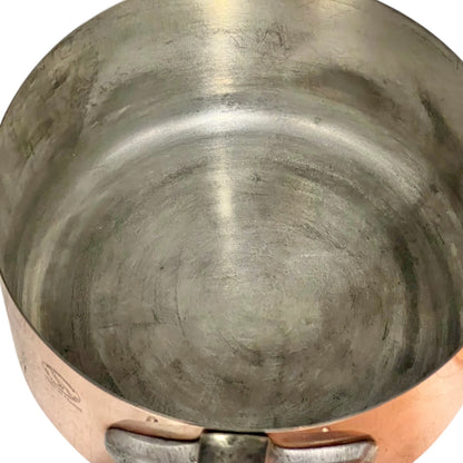 Close-up of copper cookware with iron handles on a white background