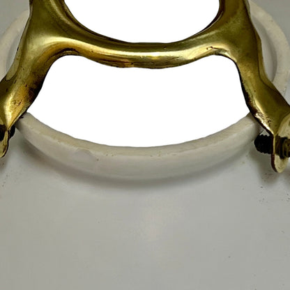 Close-up of a brass and white glass lampshade on a white background