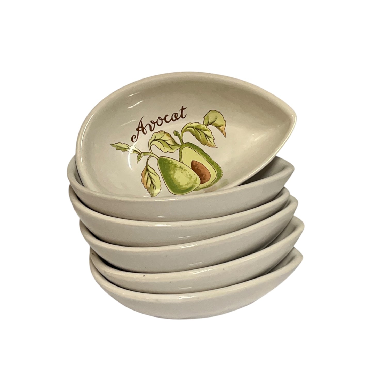 A stack of 6 small avocado-shaped ceramic bowls with a light beige glaze, featuring a painted avocado illustration and the word 'Avocat' on the top bowl, set against a plain white background.
