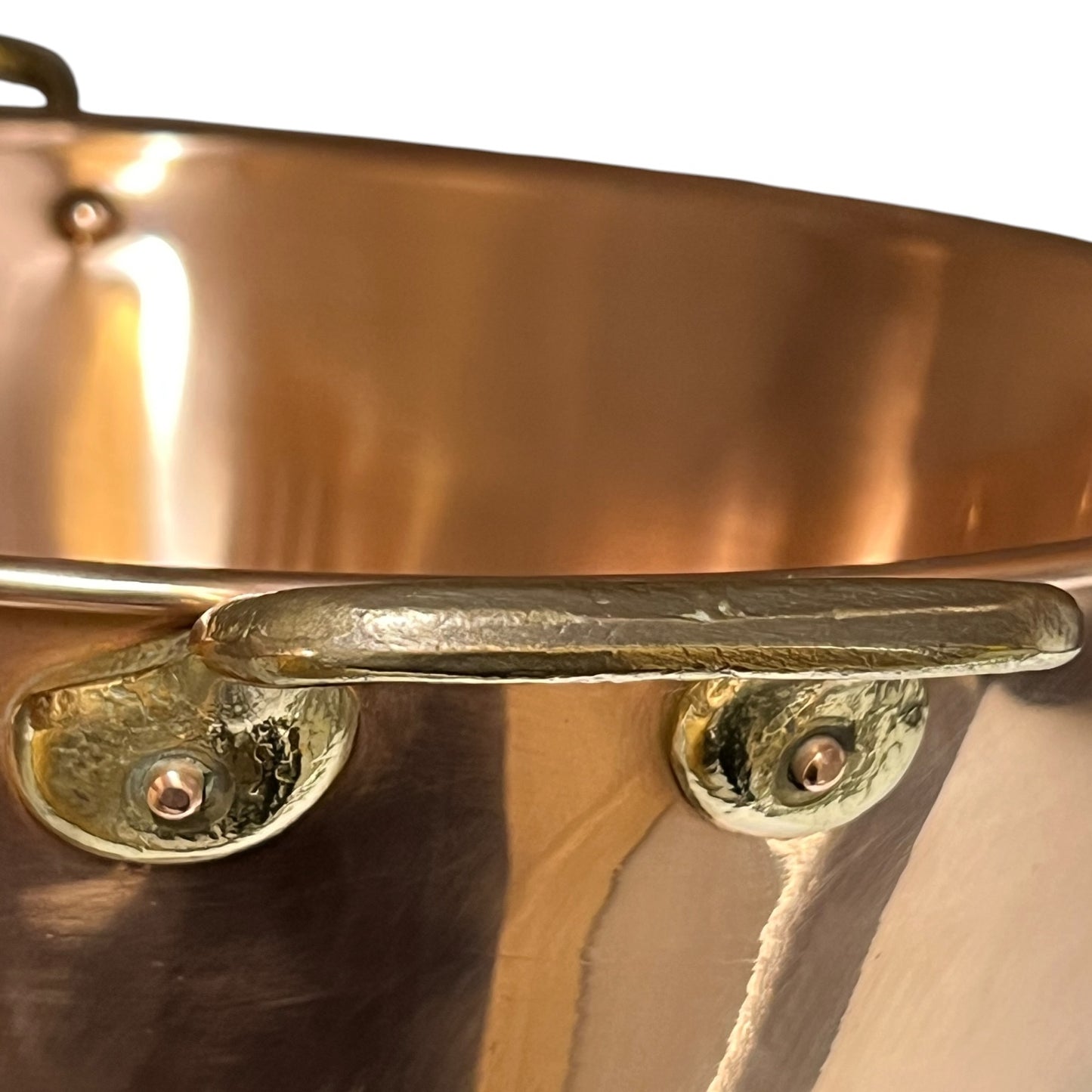 Close up view of brass handle on a copper sink 