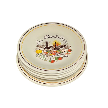 Set of round ceramic plates with decorative design and 'Les Brochettes' text on a white background