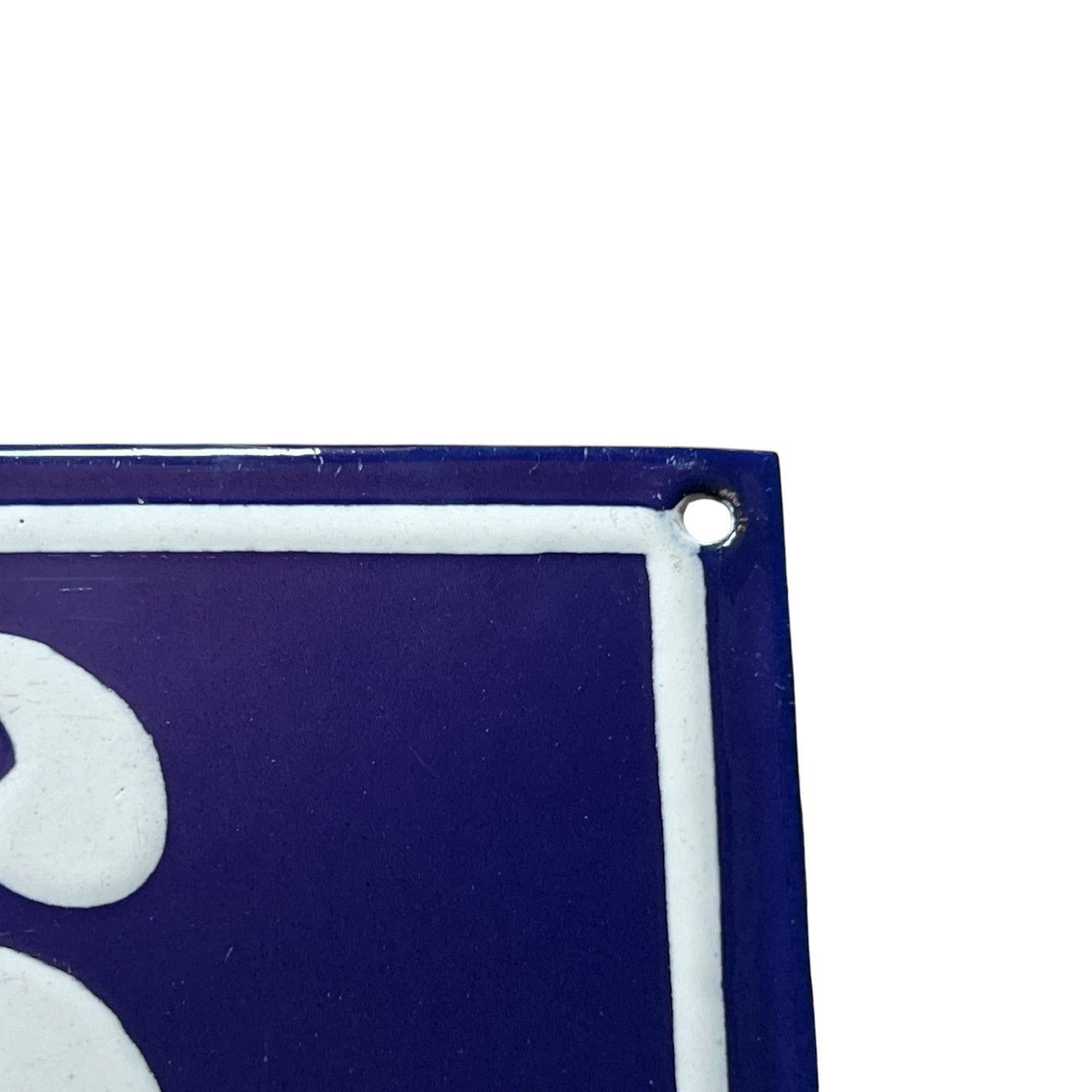 Close-up of a blue sign with white text on a white background
