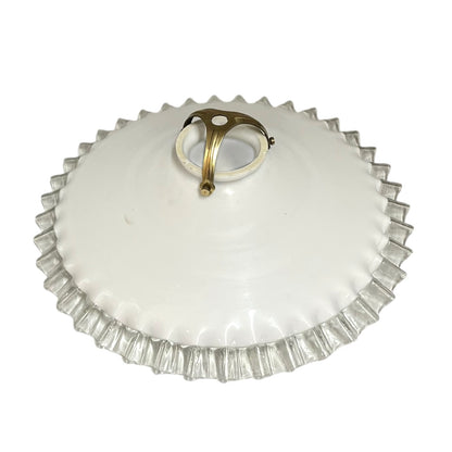 Vintage-style ceiling light fixture with white glass shade and brass fitting on a white background