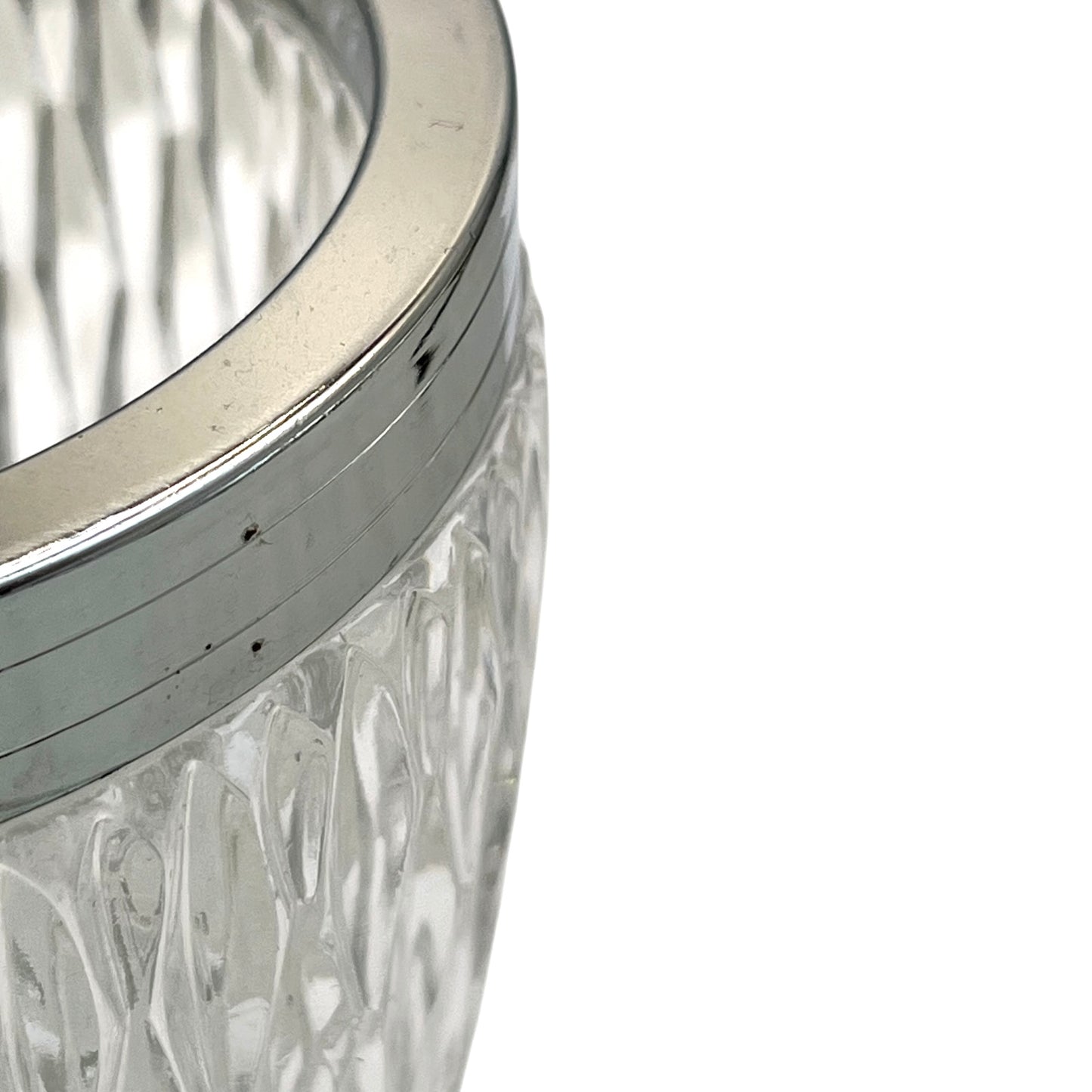 Close up of a French vintage glass ice bucket with a silver coloured collar and a handle on a white background 
