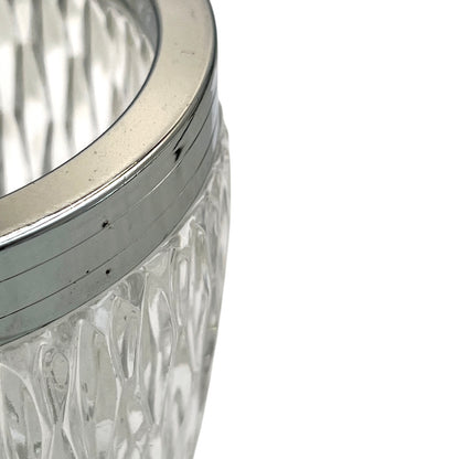 Close up of a French vintage glass ice bucket with a silver coloured collar and a handle on a white background 