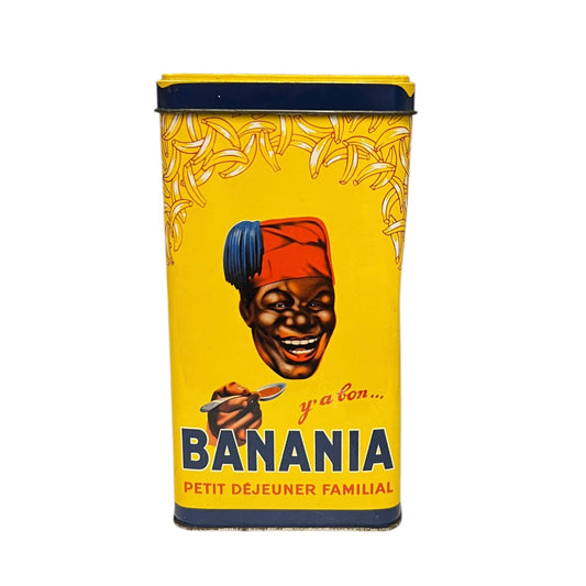 Vintage-style 'Banania' breakfast cereal can with a colourful label featuring a face and bananas on a white background.