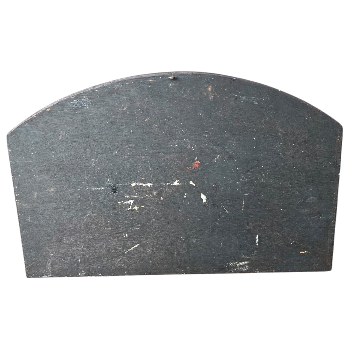 A black arched wooden board with a small pre-drilled hole at the top center, showing some wear and scuffs on the surface, set against a plain white background.