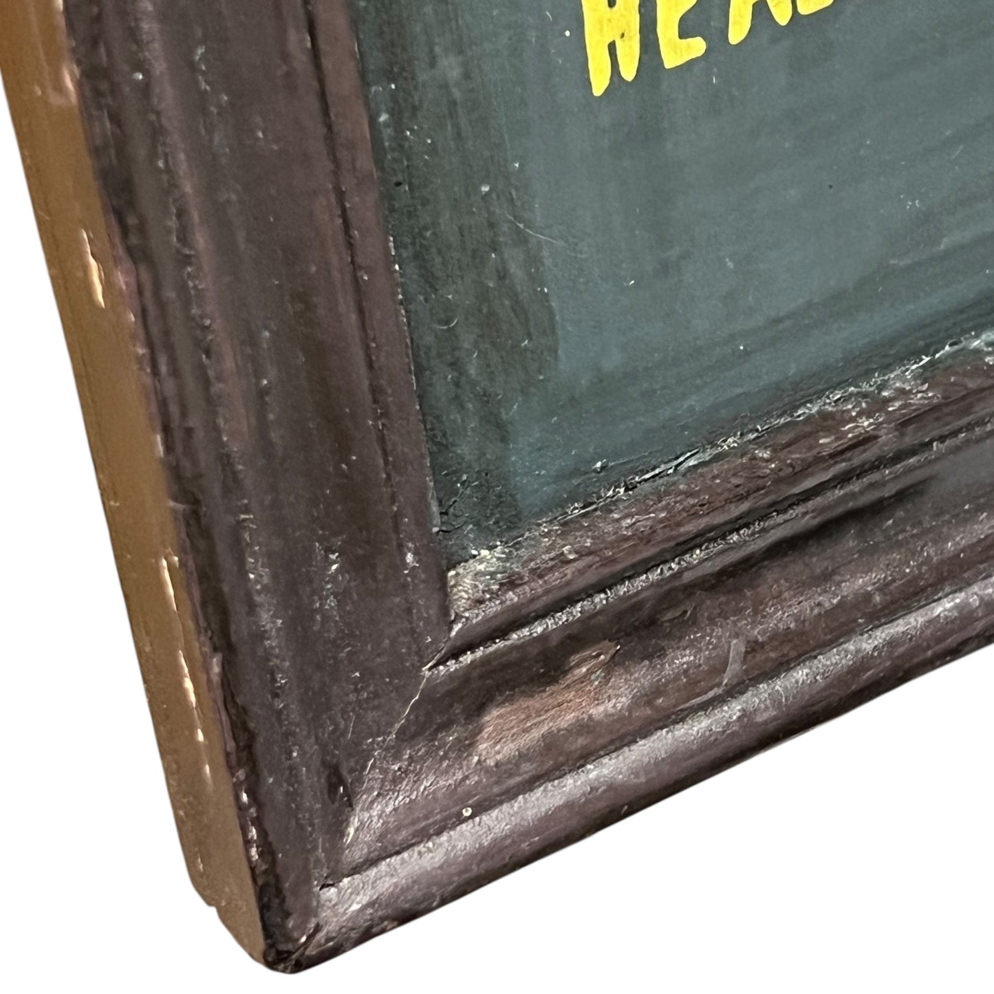 Corner of a framed picture with a dark brown frame and green interior.