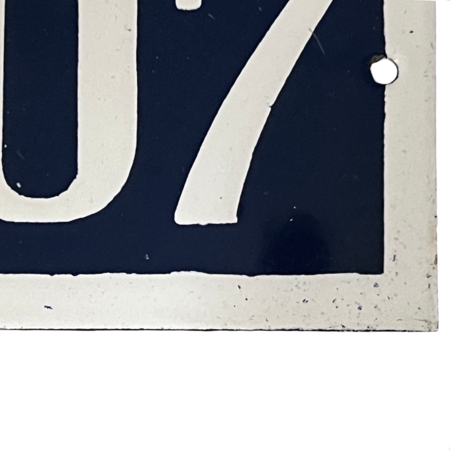 Close-up of a vintage-style license plate with the number  on a dark blue background.