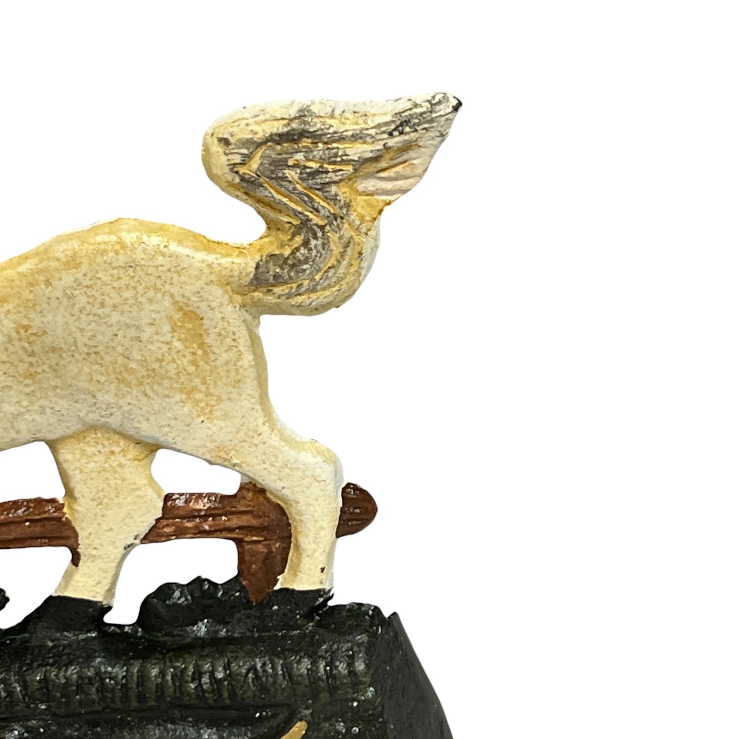 Close-up of a small decorative figurine showing part of a cream-colored animal with a textured, weathered finish, standing on a dark base against a plain white background.
