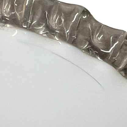 Close-up of a glass lampshade with a decorative edge on a white background