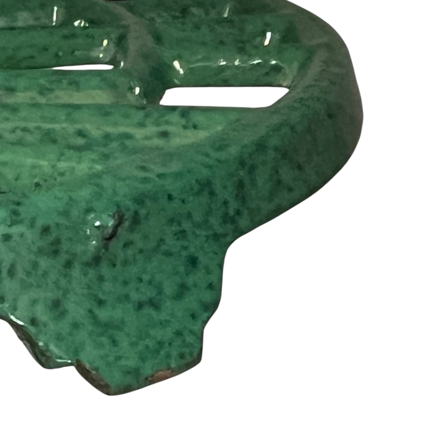 Close up of a green vintage French cast iron enamelled pan trivet on a white background
