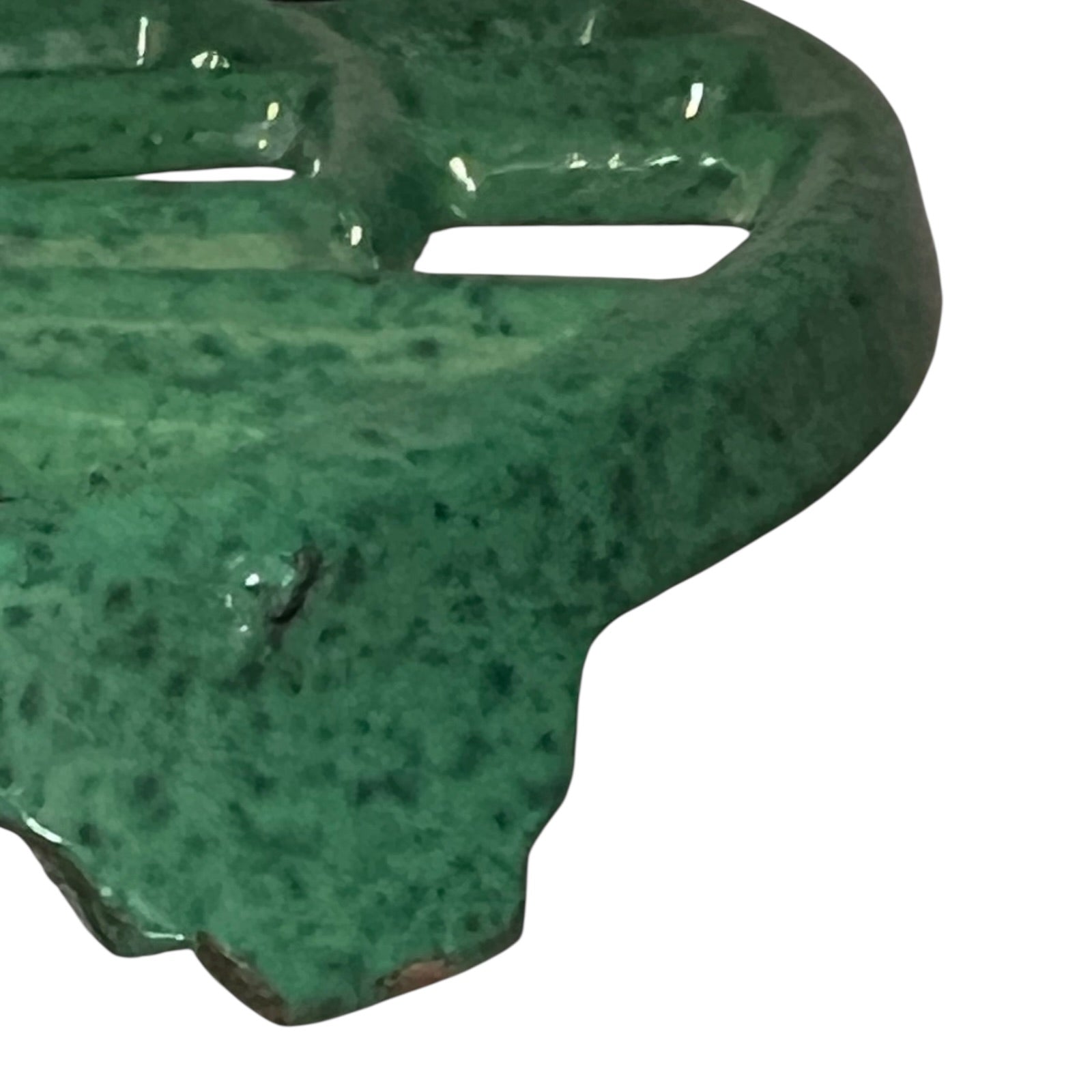 Close up of a green vintage French cast iron enamelled pan trivet on a white background