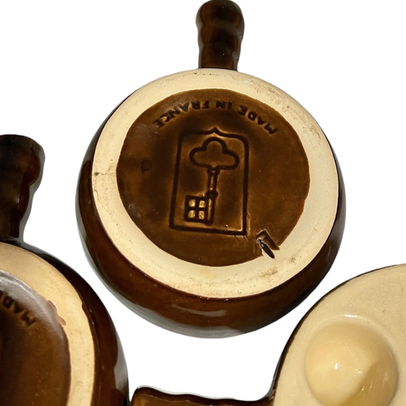 Close up of snail plates with handles and the Emile Henry makers stamp on a white background