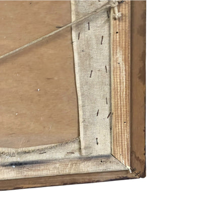 Close-up of the corner of a rustic wooden picture frame with a canvas backing and visible hanging string.