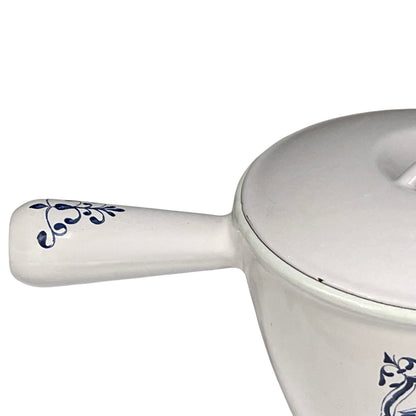 White enamelled cast iron pot with blue floral design and handle on a white background