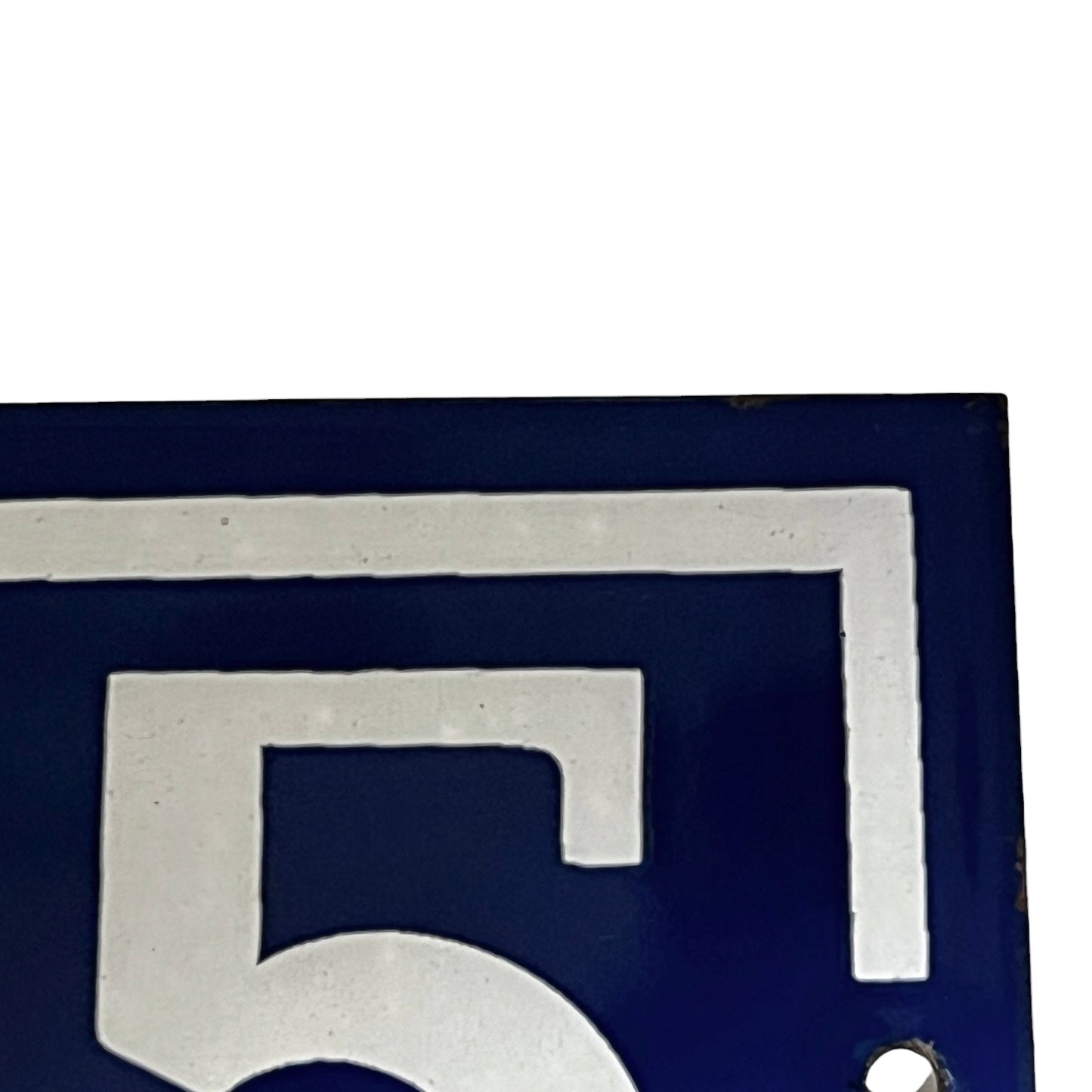 Close up of blue and white door number 65 on a white background 