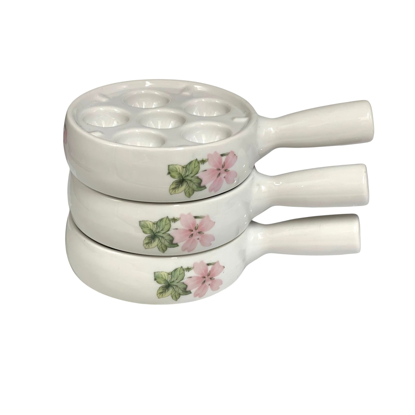 Three stacked white ceramic snail pots with floral designs of pink flowers and green leaves, set against a plain white background.