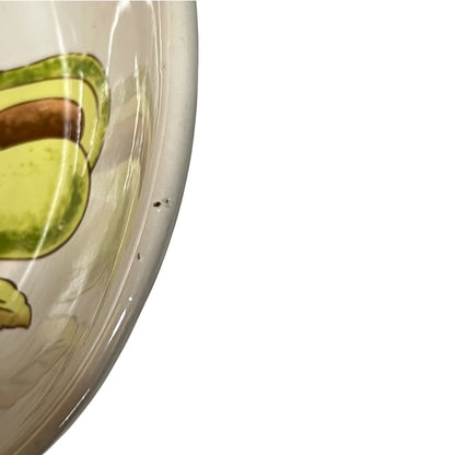 Close-up of a ceramic bowl showing a partial avocado illustration on a white background.