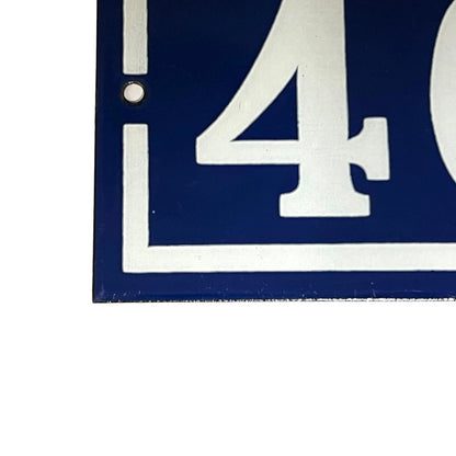 Close up of a French enamel door number on a white background 