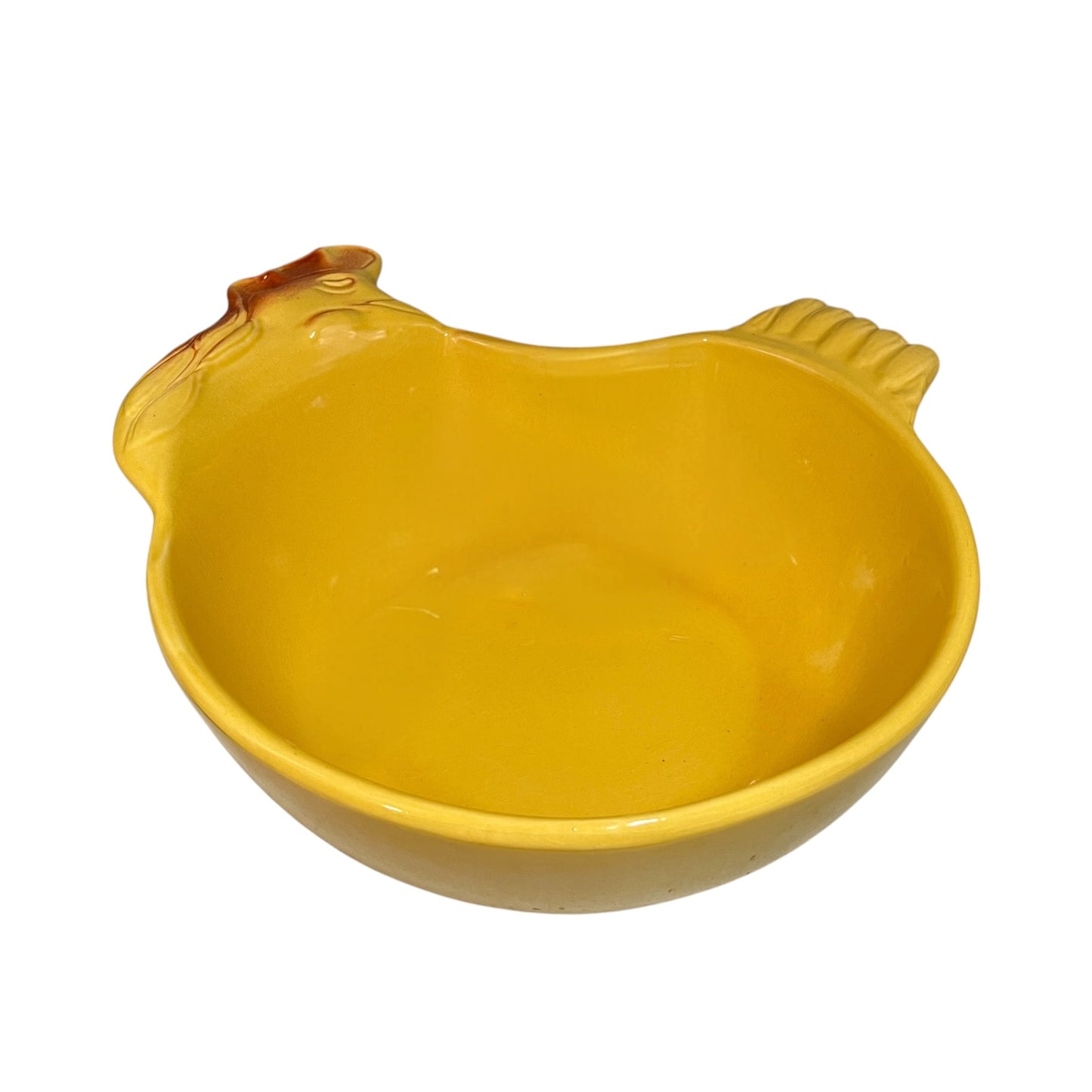 A yellow ceramic chicken-shaped bowl with a glossy finish, featuring a small handle on the left with a brown accent and a textured handle on the right, set against a plain white background.
