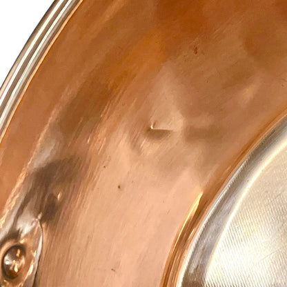Close-up of a copper basin with a reflective finish on a white background 