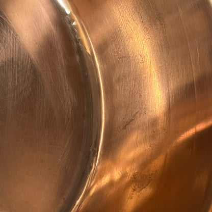 Close-up of a copper sink with a drain plug