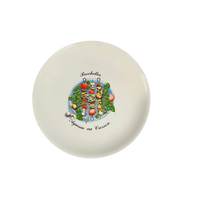 Round ceramic plate with vegetable skewer design and text on a white background