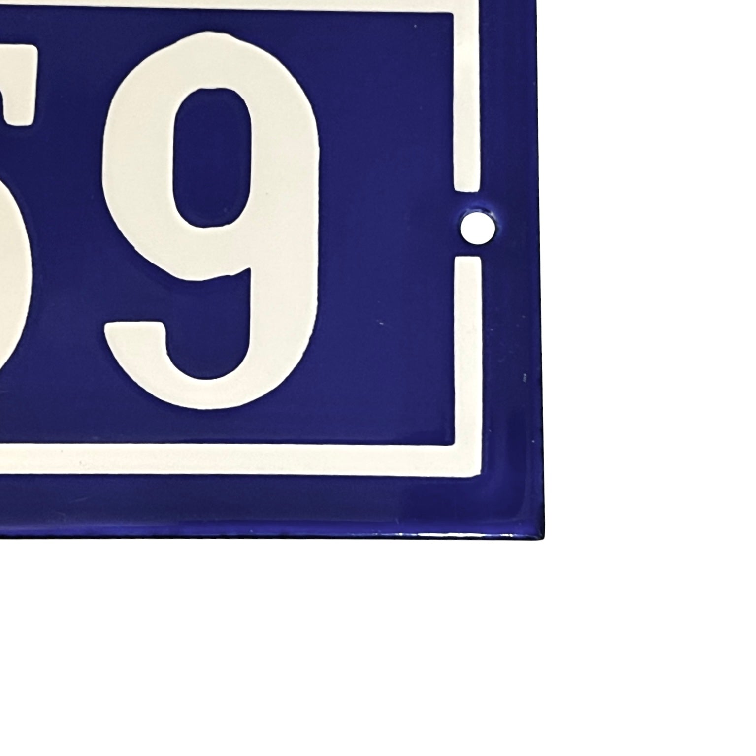 Close up of a French blue and white door number on a white background 