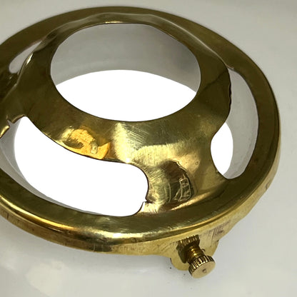A close-up of a polished brass circular hardware component with a knurled adjustment screw, set against a plain white background.