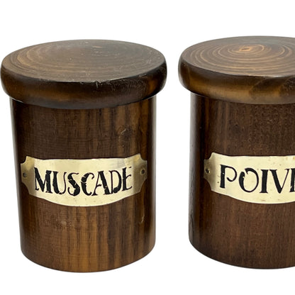Two wooden jars with labels 'Muscade' and 'Poivre' on a white background